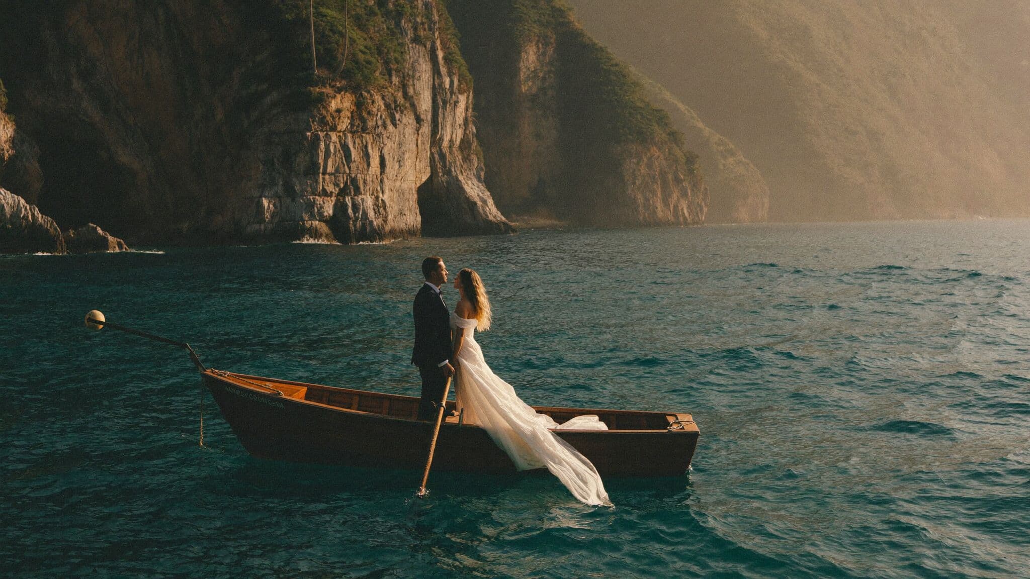 Newlyweds on a private boat below the Positano cliffs during an Amalfi Coast elopement