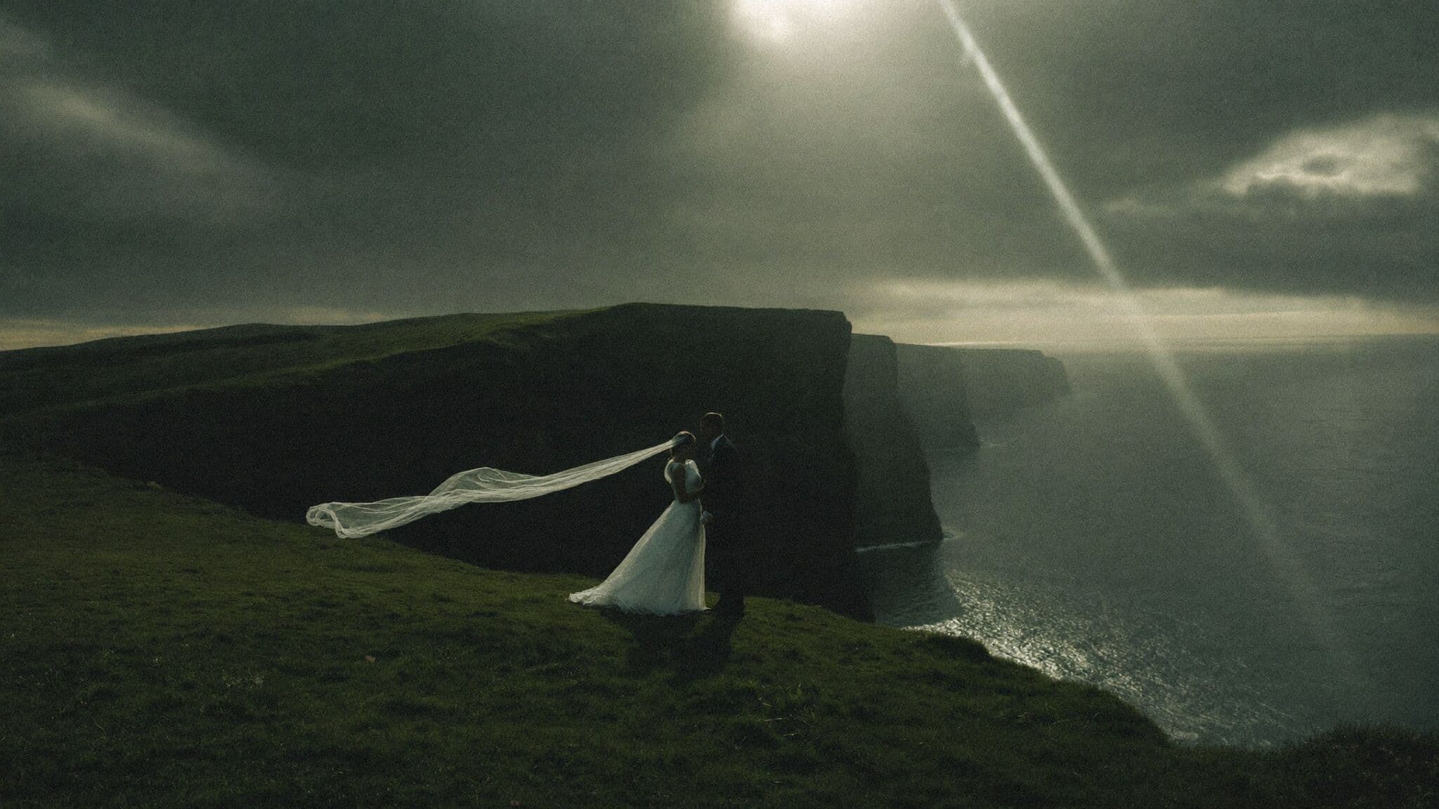 Couple embracing on the clifftop path at the Cliffs of Moher during their Ireland elopement