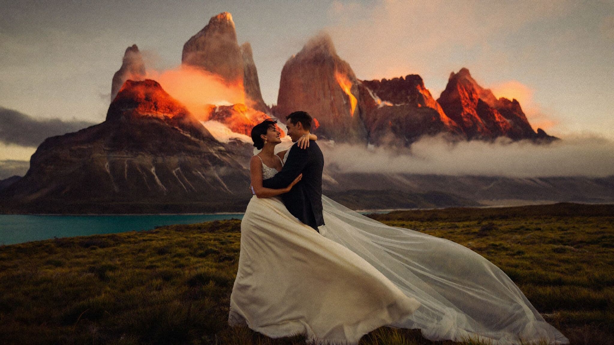 Couple embracing before the granite towers of Torres del Paine at sunrise, Patagonia elopement