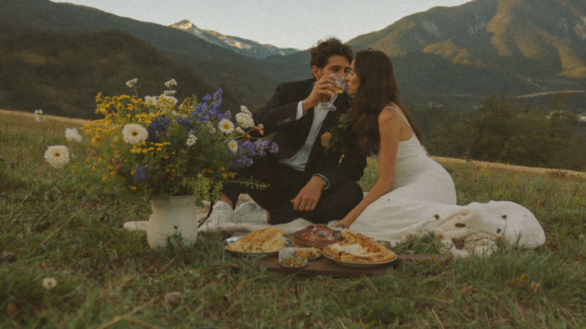 Small group of family toasting a couple at their elopement picnic in a mountain meadow