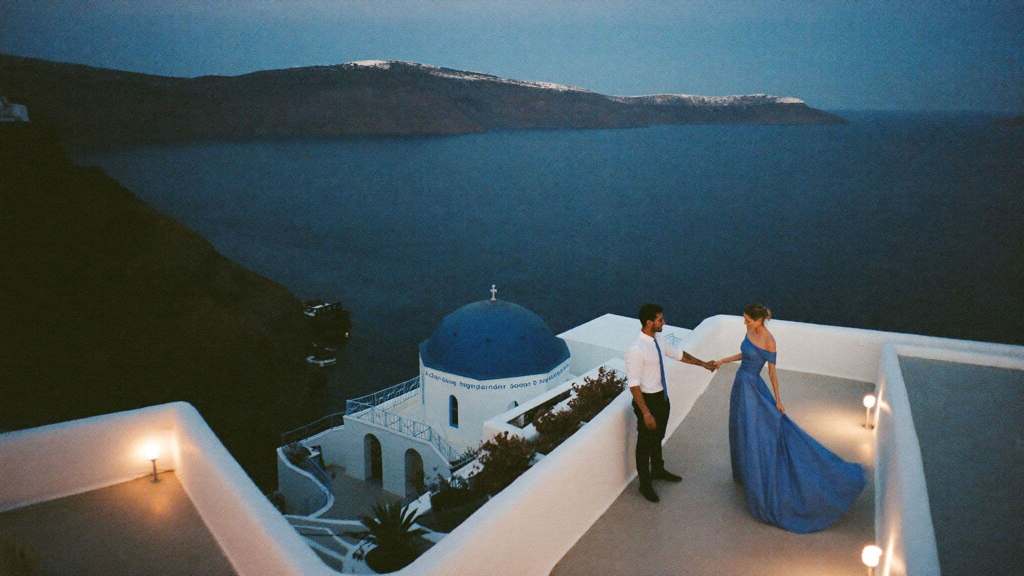 Couple exchanging vows on a caldera cliff above the Aegean during their Santorini elopement