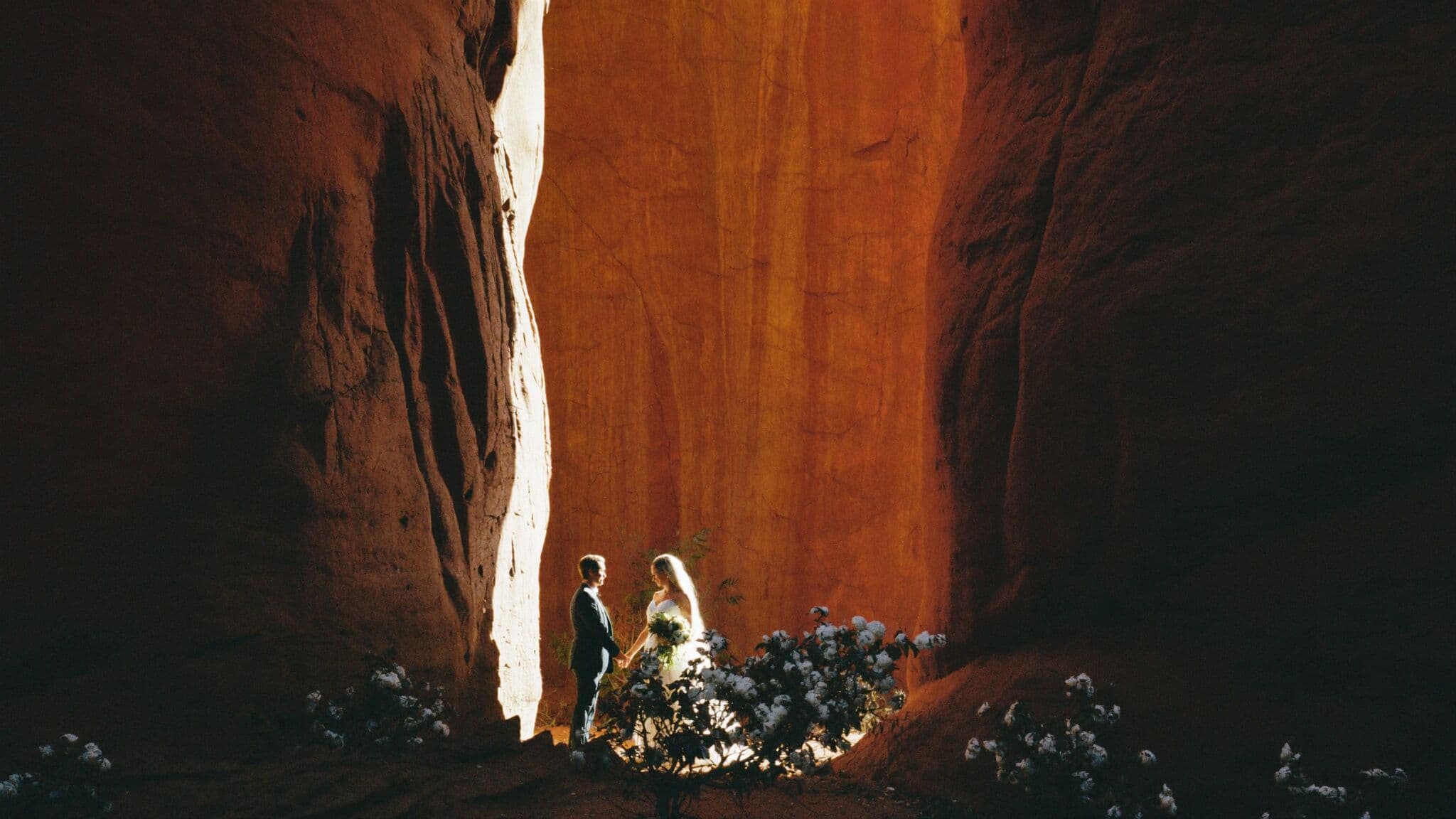 Bride and groom during their Zion elopement with red canyon walls rising behind them